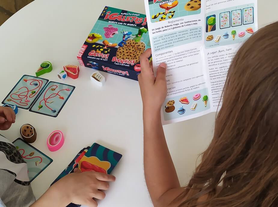 foto de una niña leyendo las instrucciones del juego de mesa galletas en una actividad ludica de refuerzo divertido